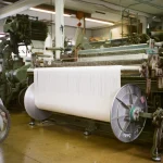 Industrial weaving looms producing fabric