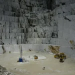 Stone cutting machine slicing a limestone block at a Hebron stone factory